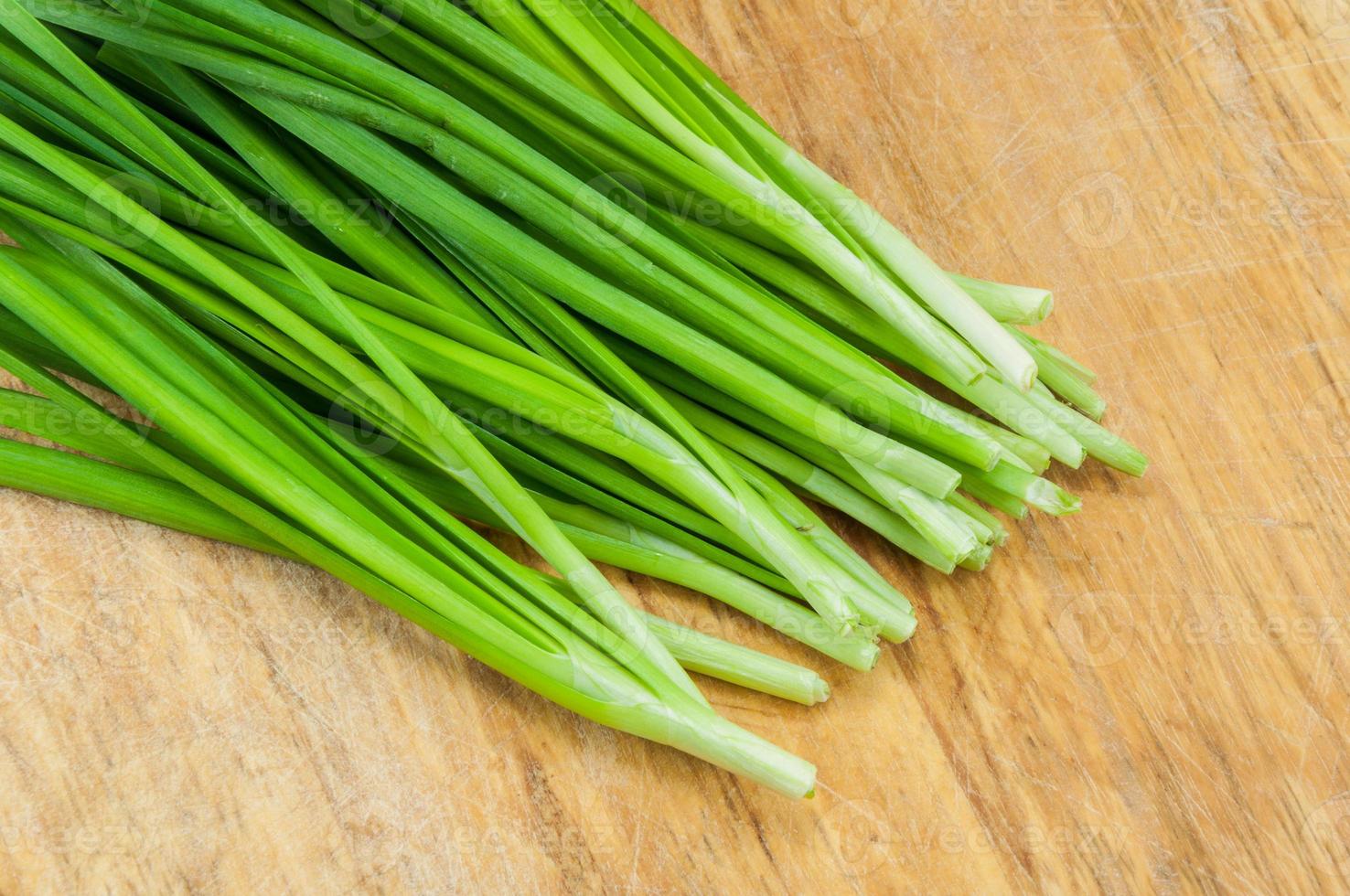 green onions on a wooden chopping board photo