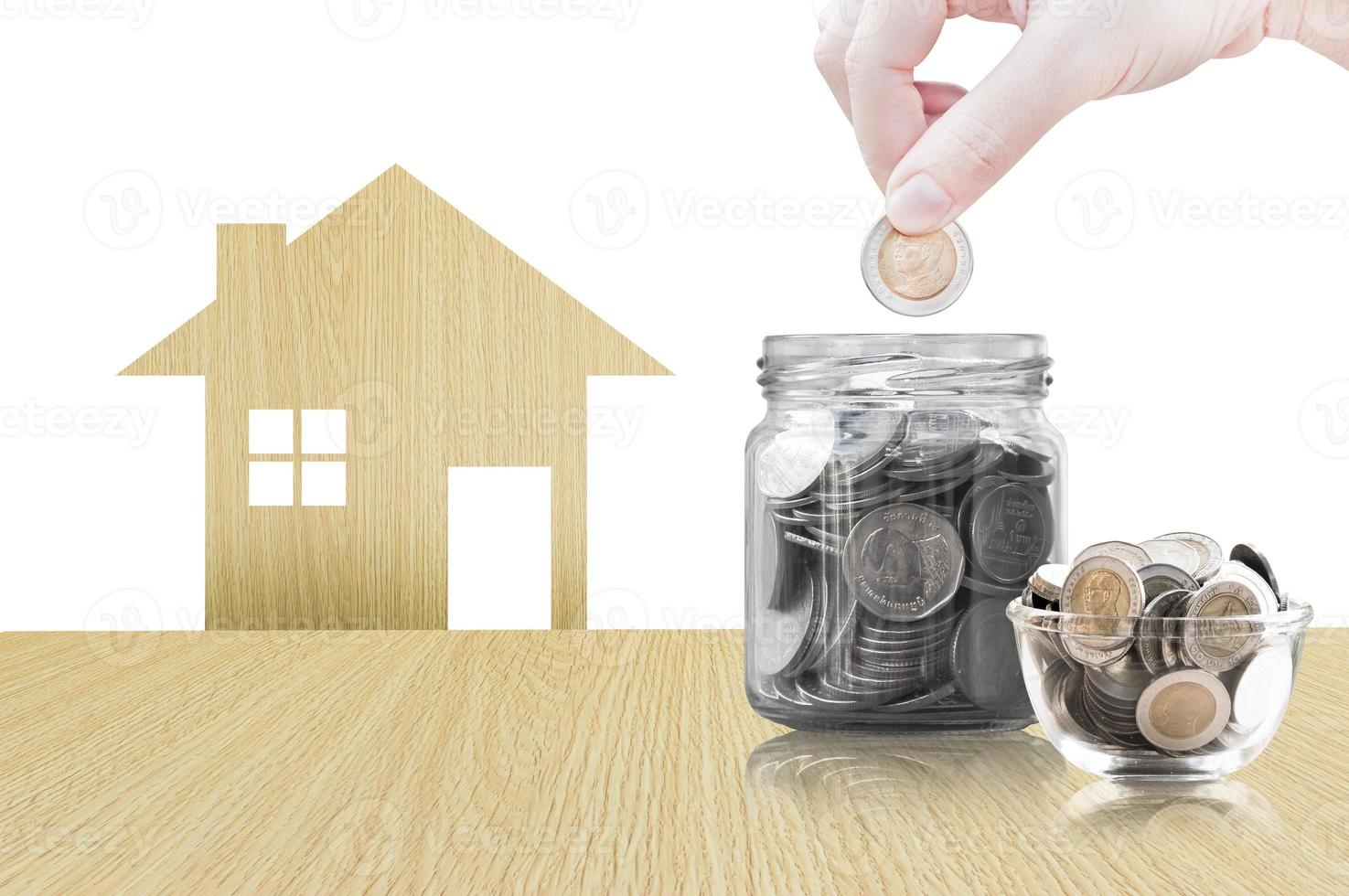 Hand putting coin into glass container of buying a new house - saving money for future concept,house savings coins. isolated on white background photo