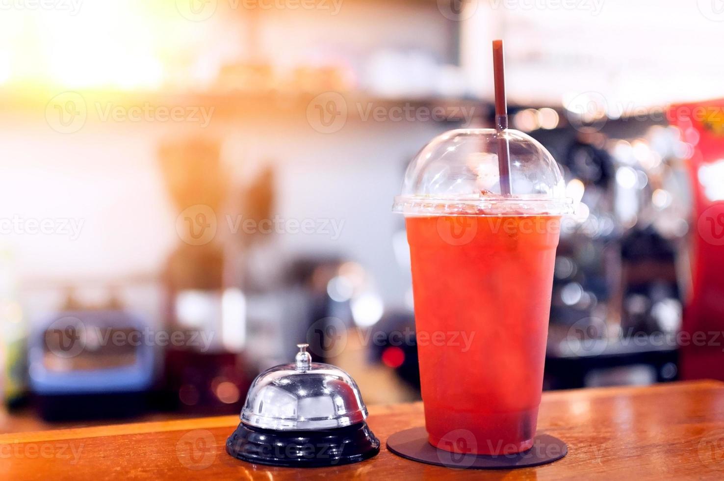 Iced honey lemon tea Beverage in plastic glass and service bell on the table in cafe,Summer drinks with ice photo