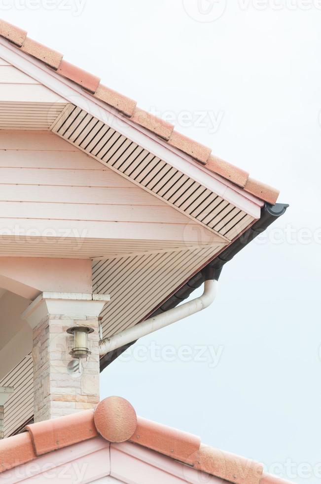 Weathered roof with rain gutter of roof top of house photo