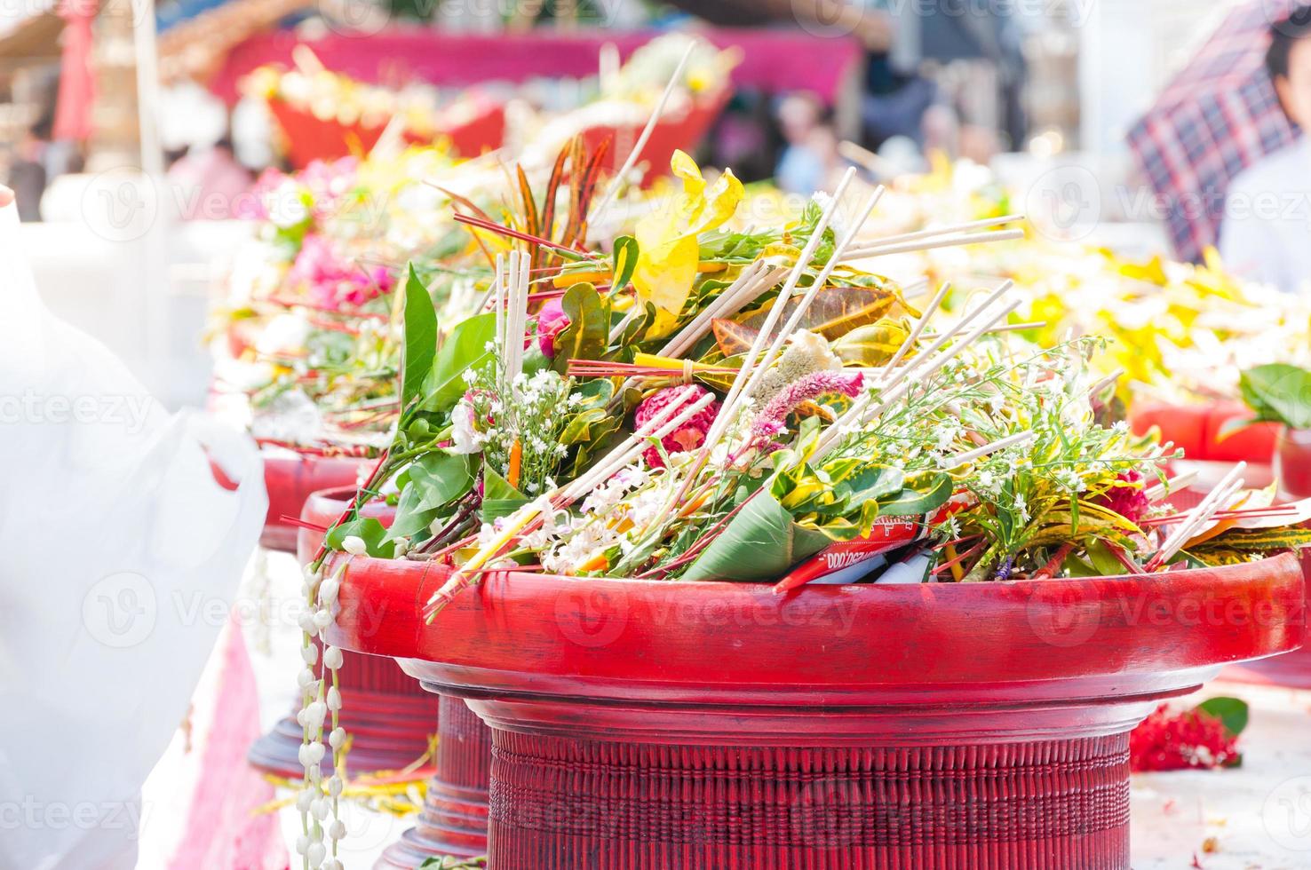 Thai traditional of flowers to Buddhist monks ceremony at  Wat che di Luang Chiang Mai, Thailand in the background there is incenses, candles and flowers photo