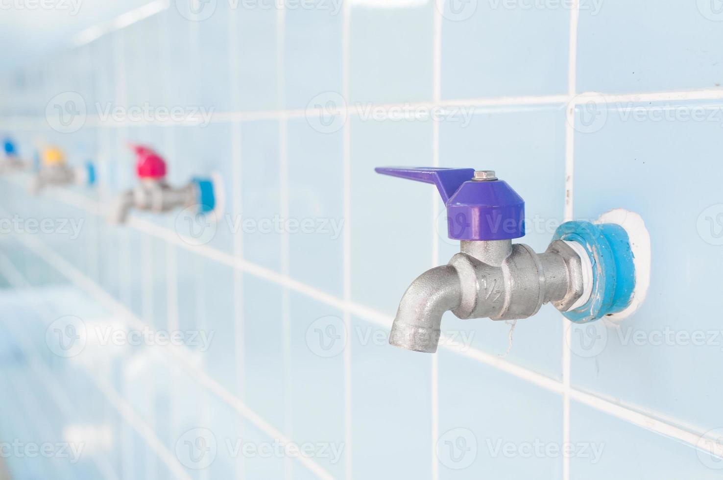 Colorful Faucet on a blue wall photo