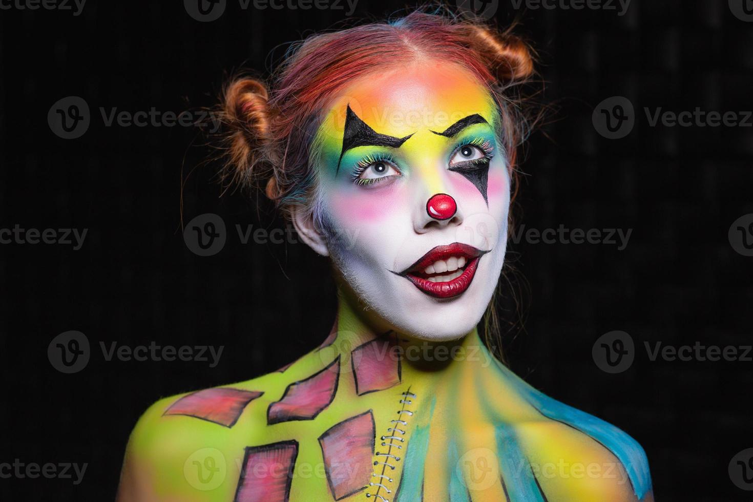 Cute young woman with a face painting clown photo