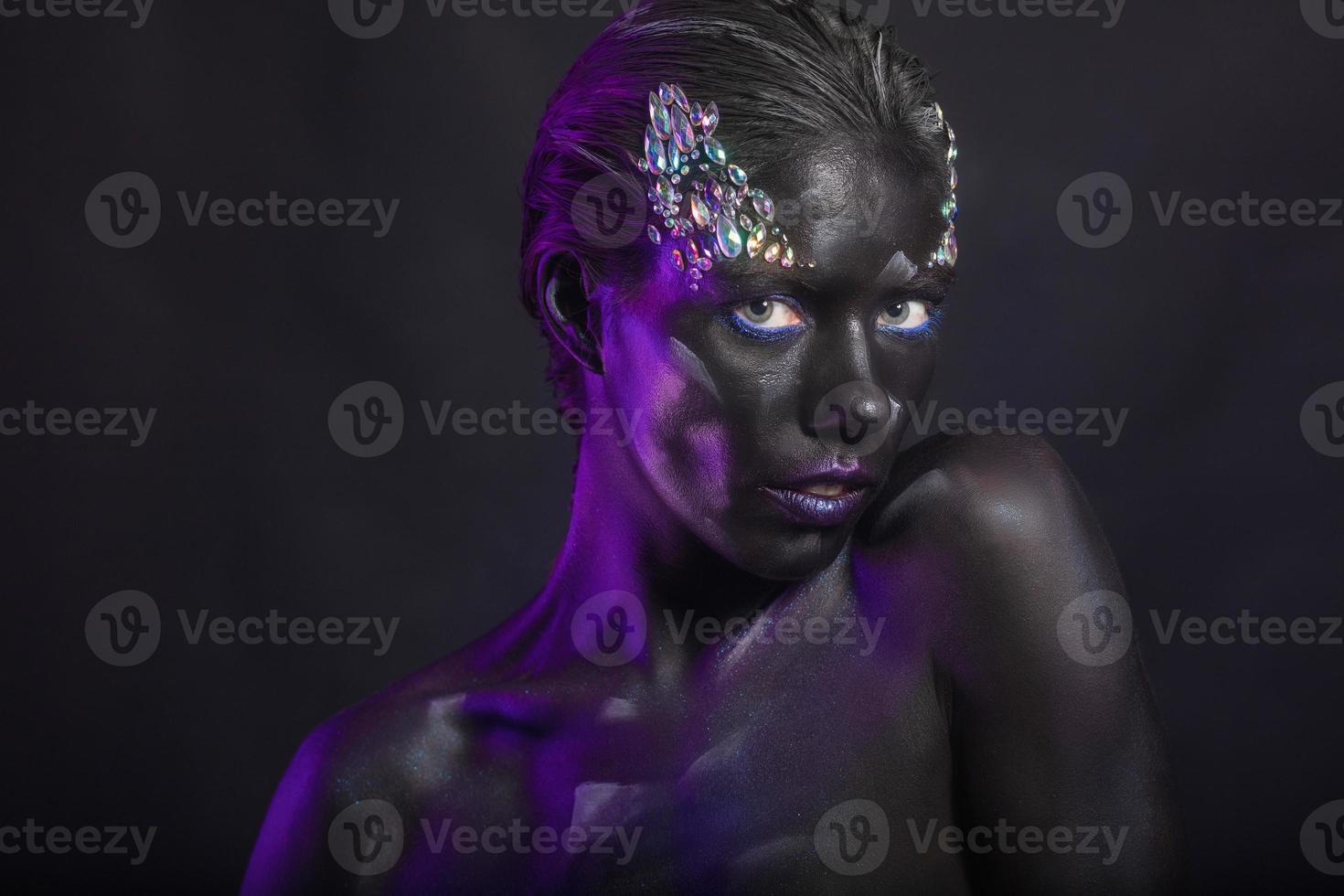 Charming young brunette with creative makeup on face photo