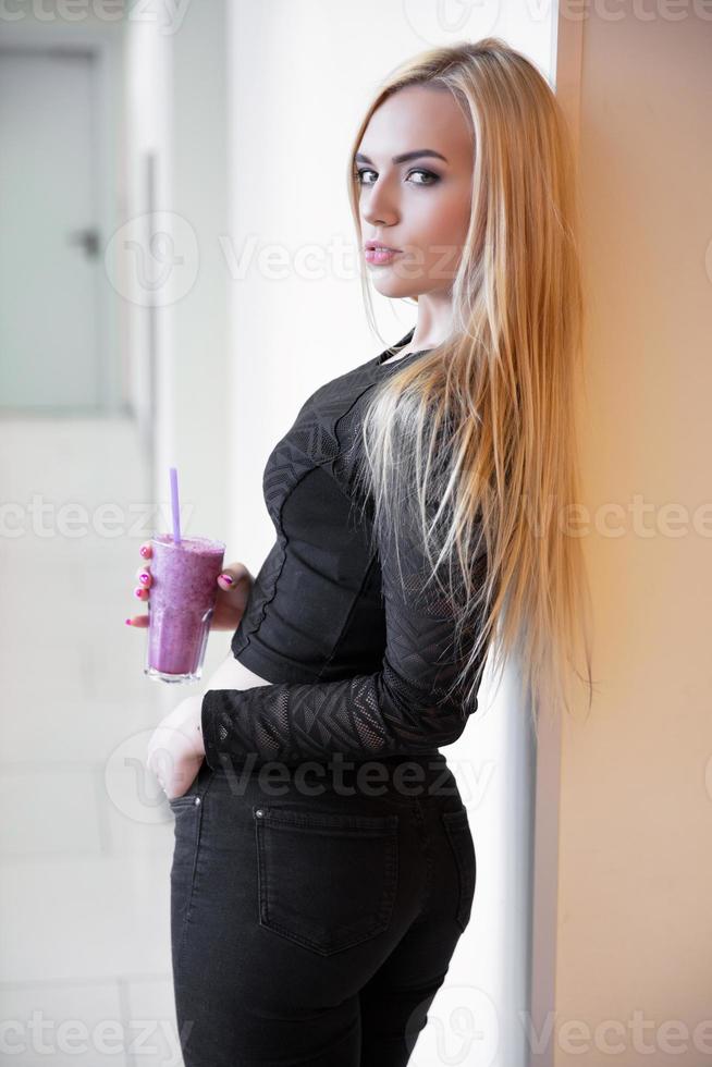 Luxury blonde posing near the wall photo