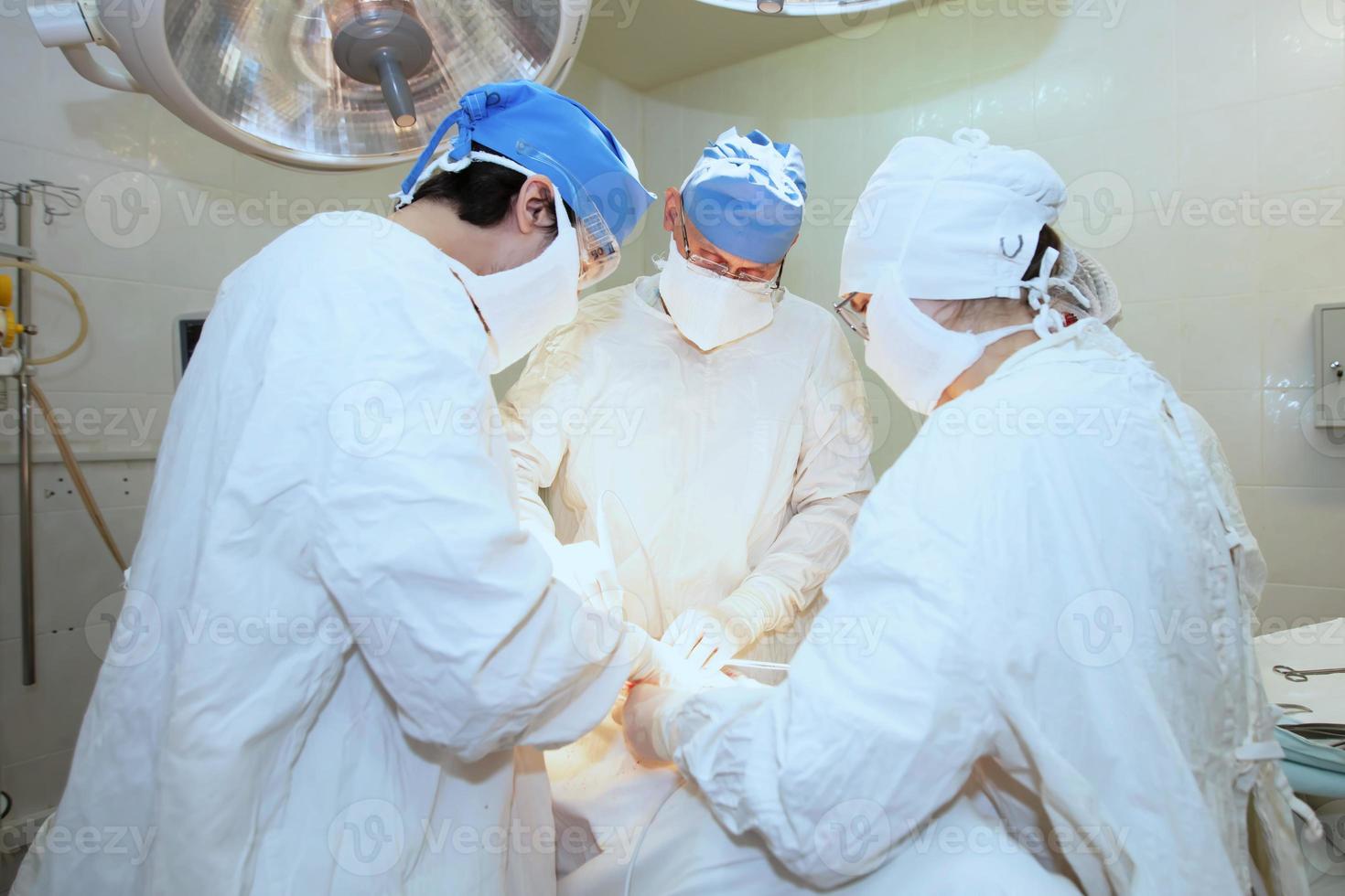cirujanos durante el operación. profesional doctores ejecutando cirugías foto