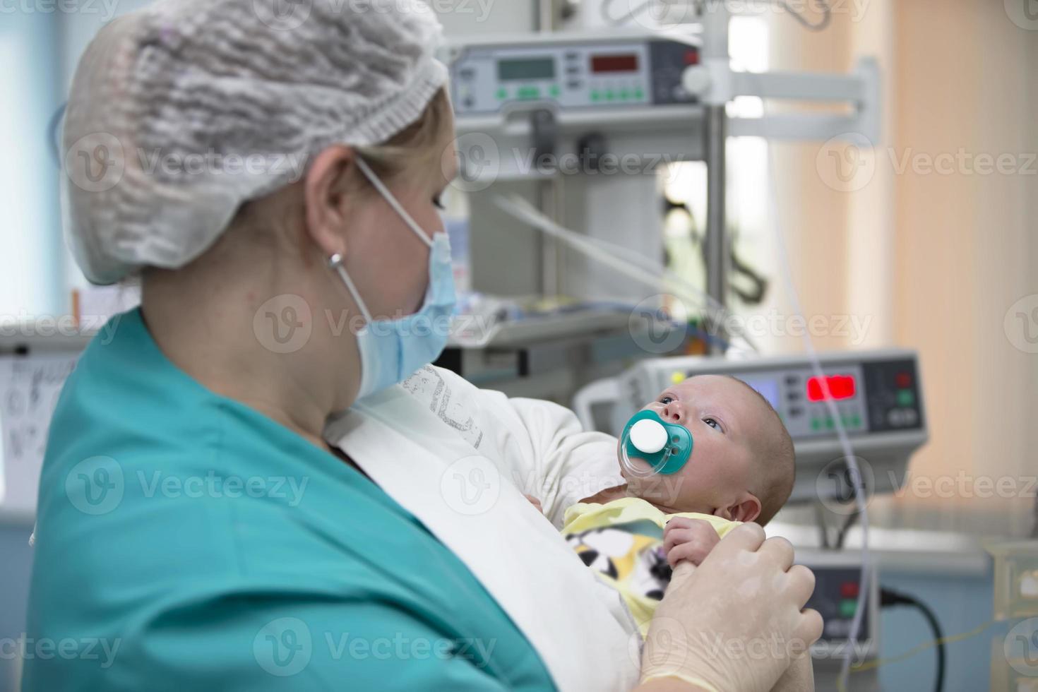 enfermero con un bebé en intensivo cuidado. recién nacido bebé en el hospital. foto