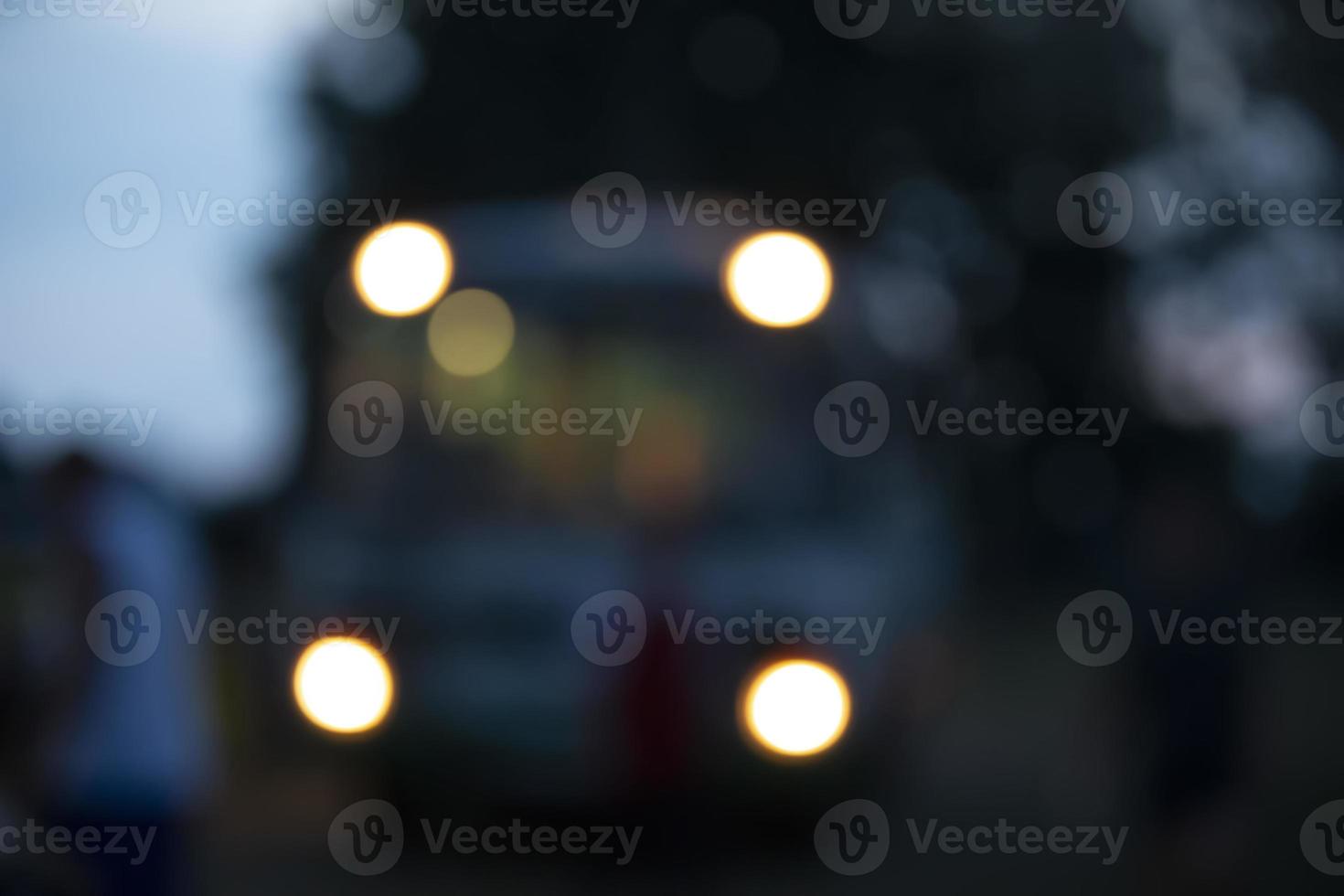 Bokeh yellow from the headlights of the bus on a dark blue background. photo