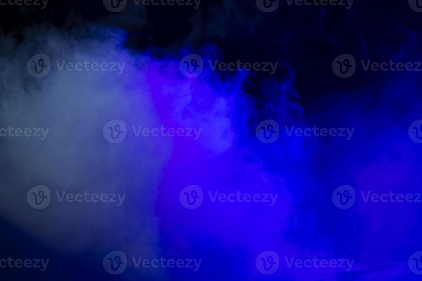 On a black background, a blue spot of blurred smoke.Abstract mystical background. photo