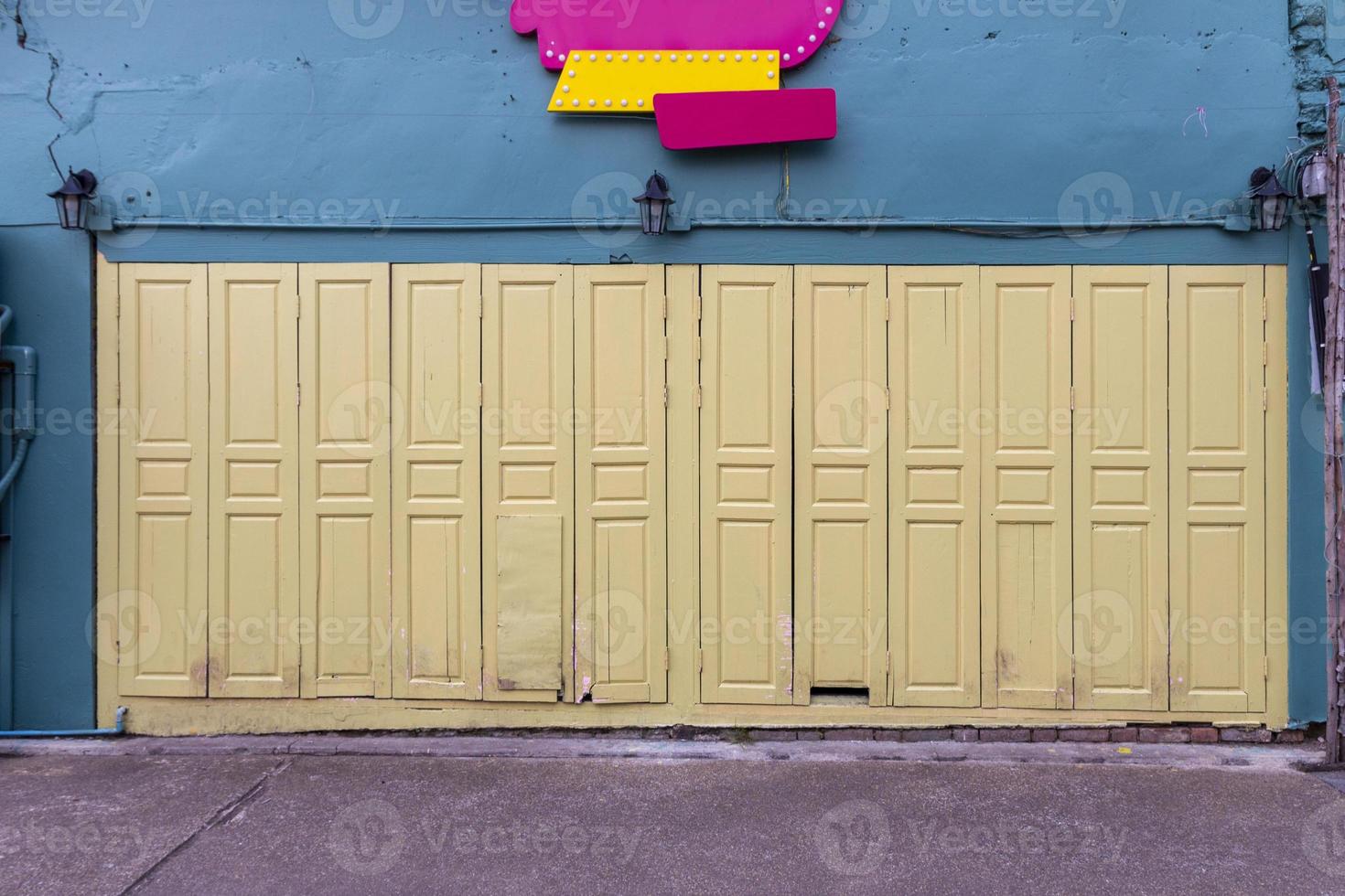 The colorful front door against the bright turquoise building with a sign above it. photo