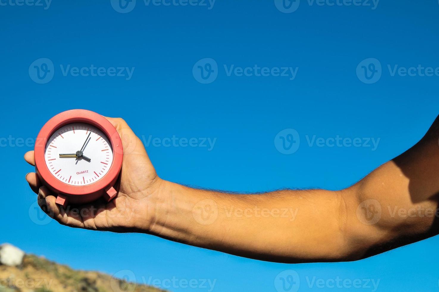 Hand holding alarm clock photo