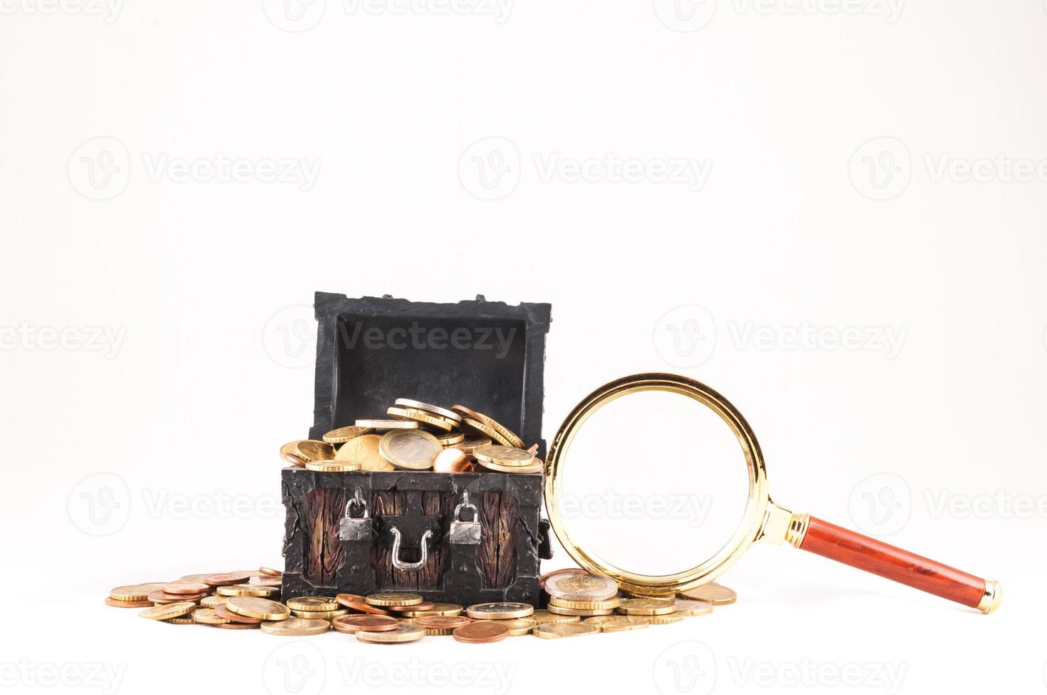 Treasure box, coins and magnifying glass photo