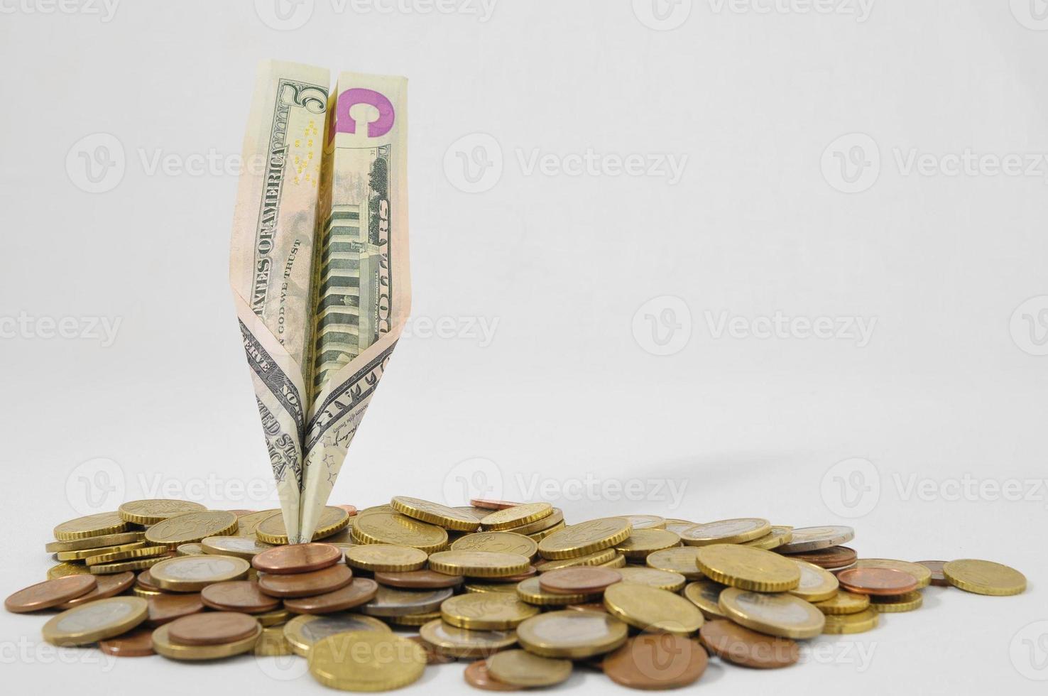 Coins and a paper plane made of USD banknote photo