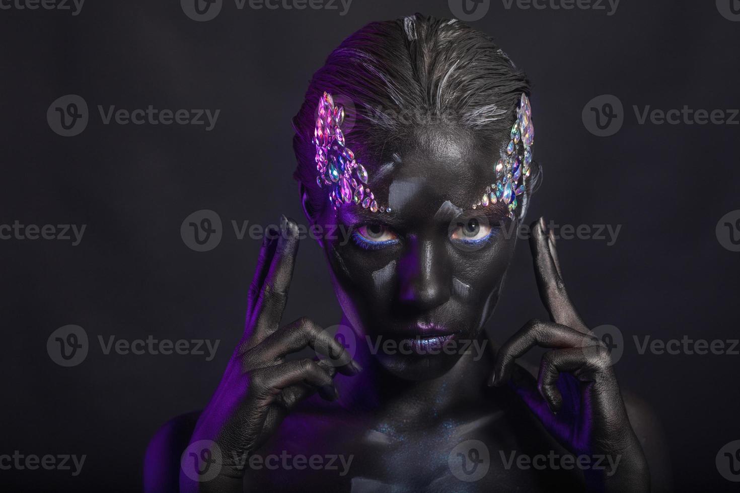 Young brunette with creative makeup on face photo