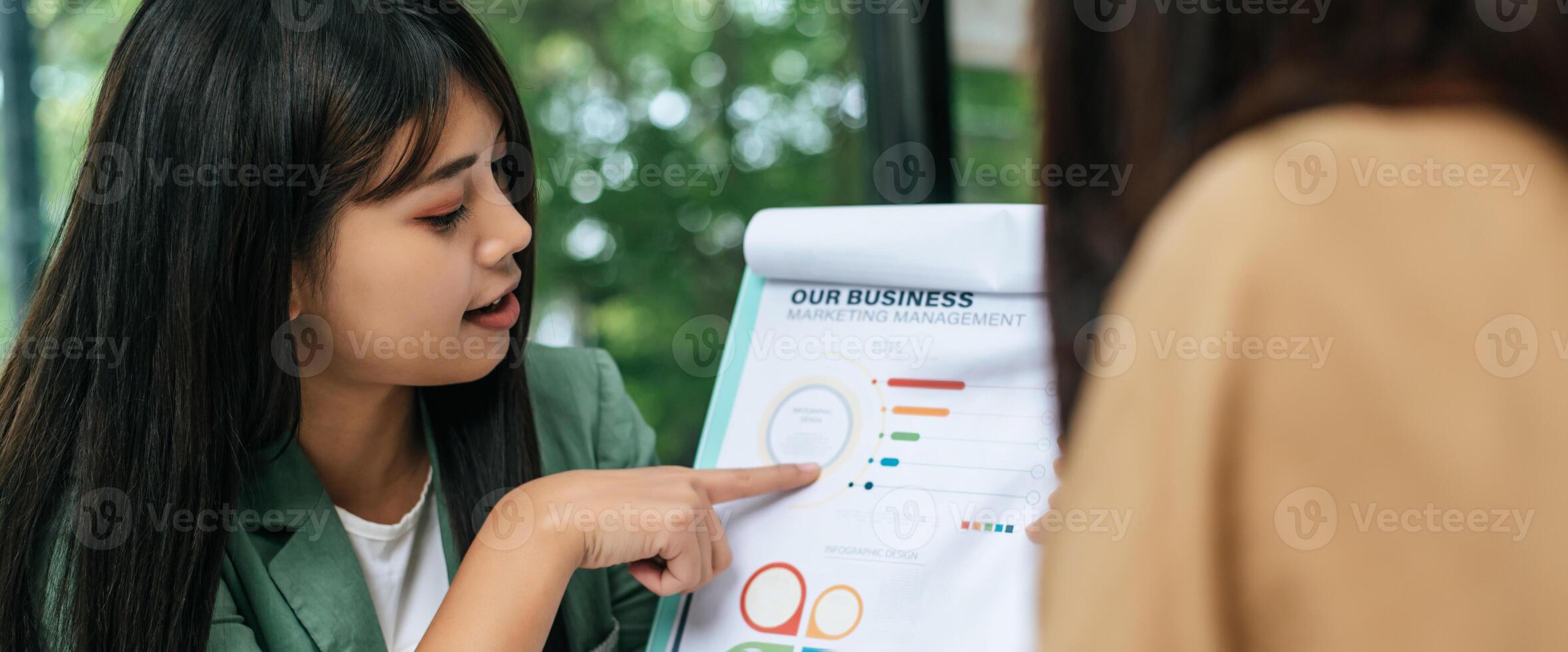 Young woman and friend working with paper work at coffee shop photo
