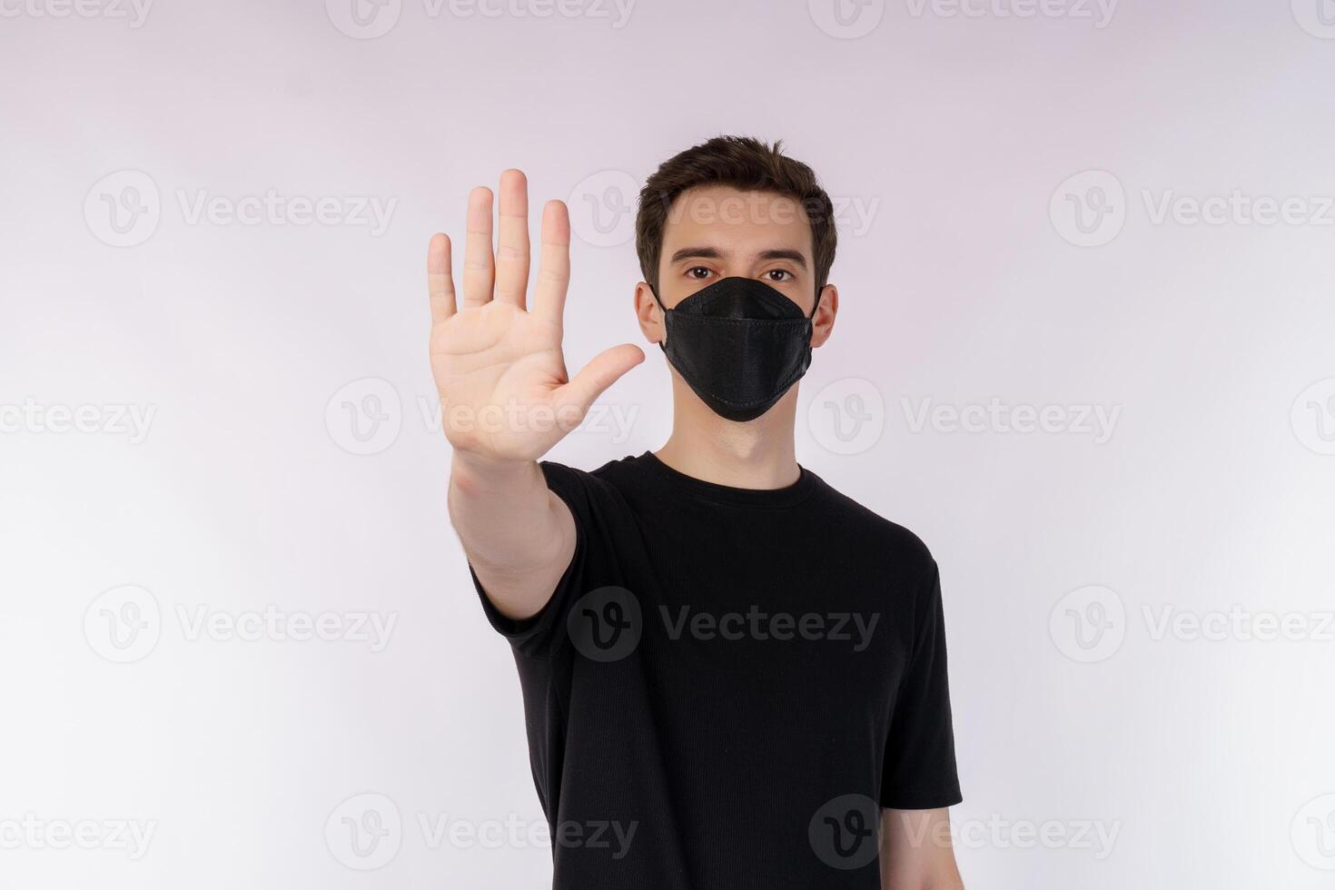 Portrait of young handsome man wearing medical mask doing stop sing with palm of the hand over white background photo