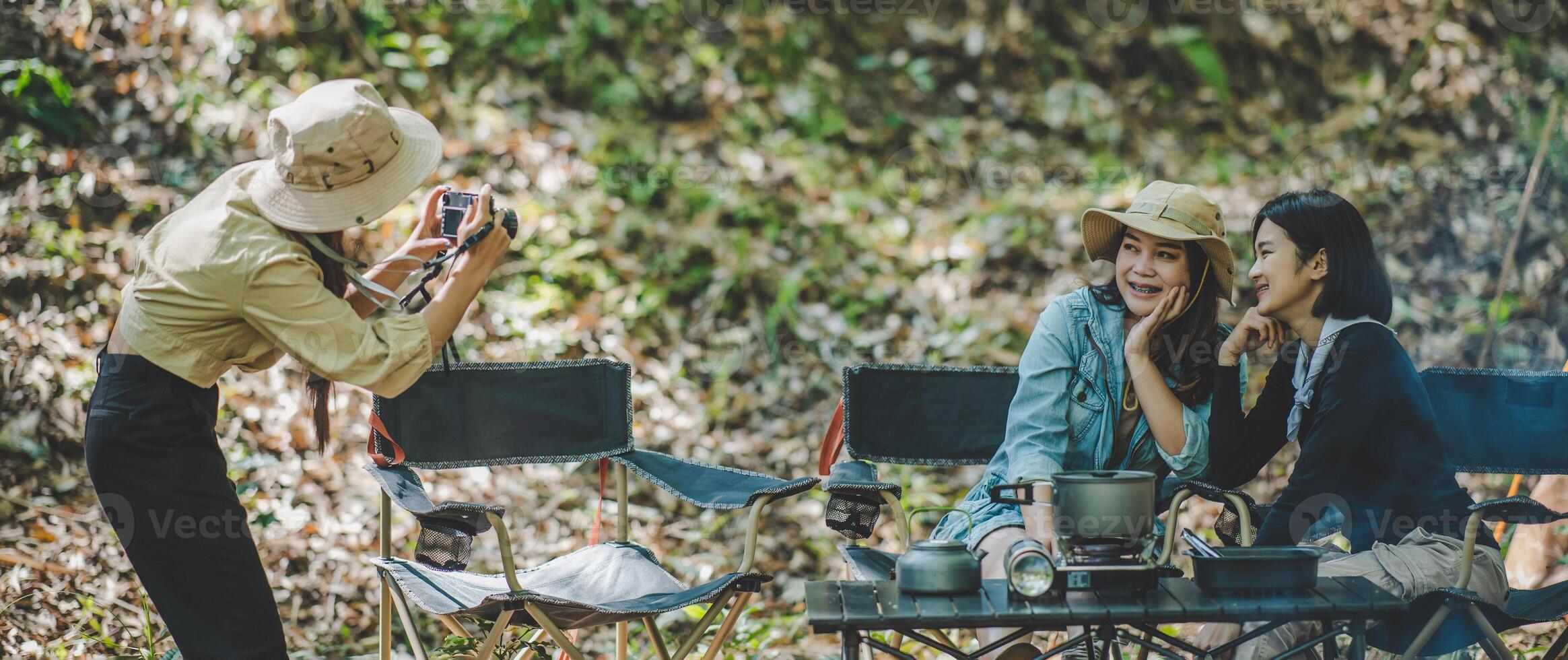 Young photographer use digital camera photography her friend on camping photo