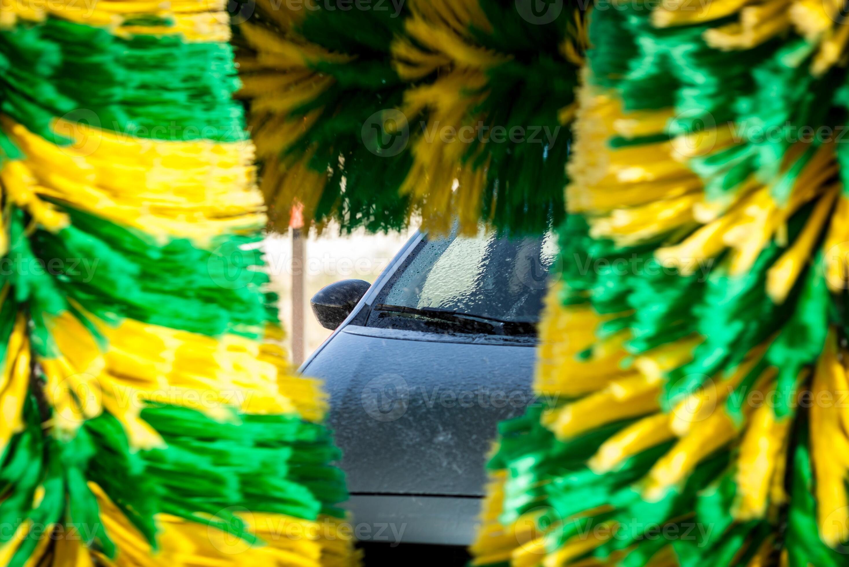 Worker washing car with sponge on a car wash, Manual car wash with