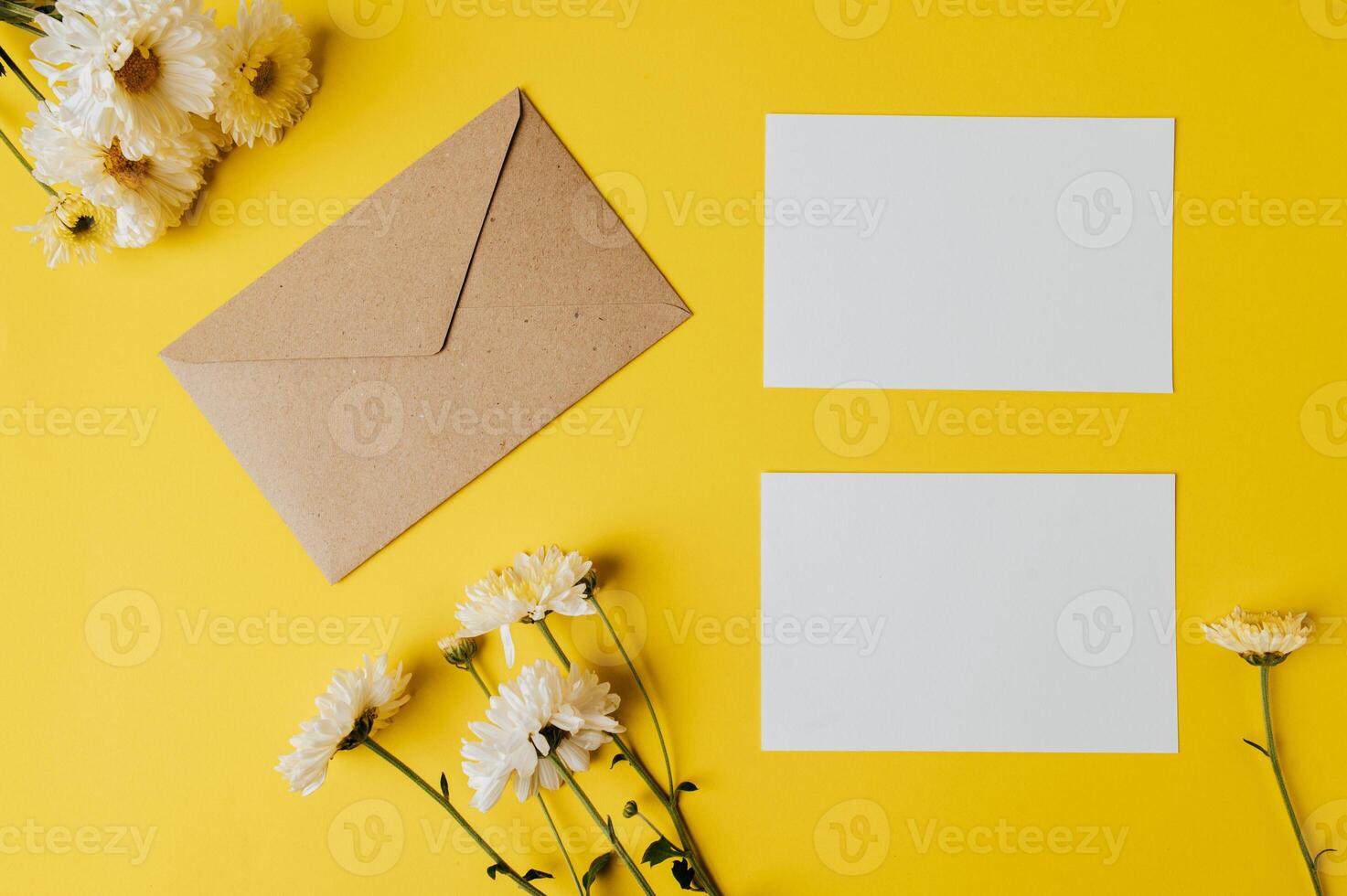brown envelope and card on yellow background decorated with flowers photo