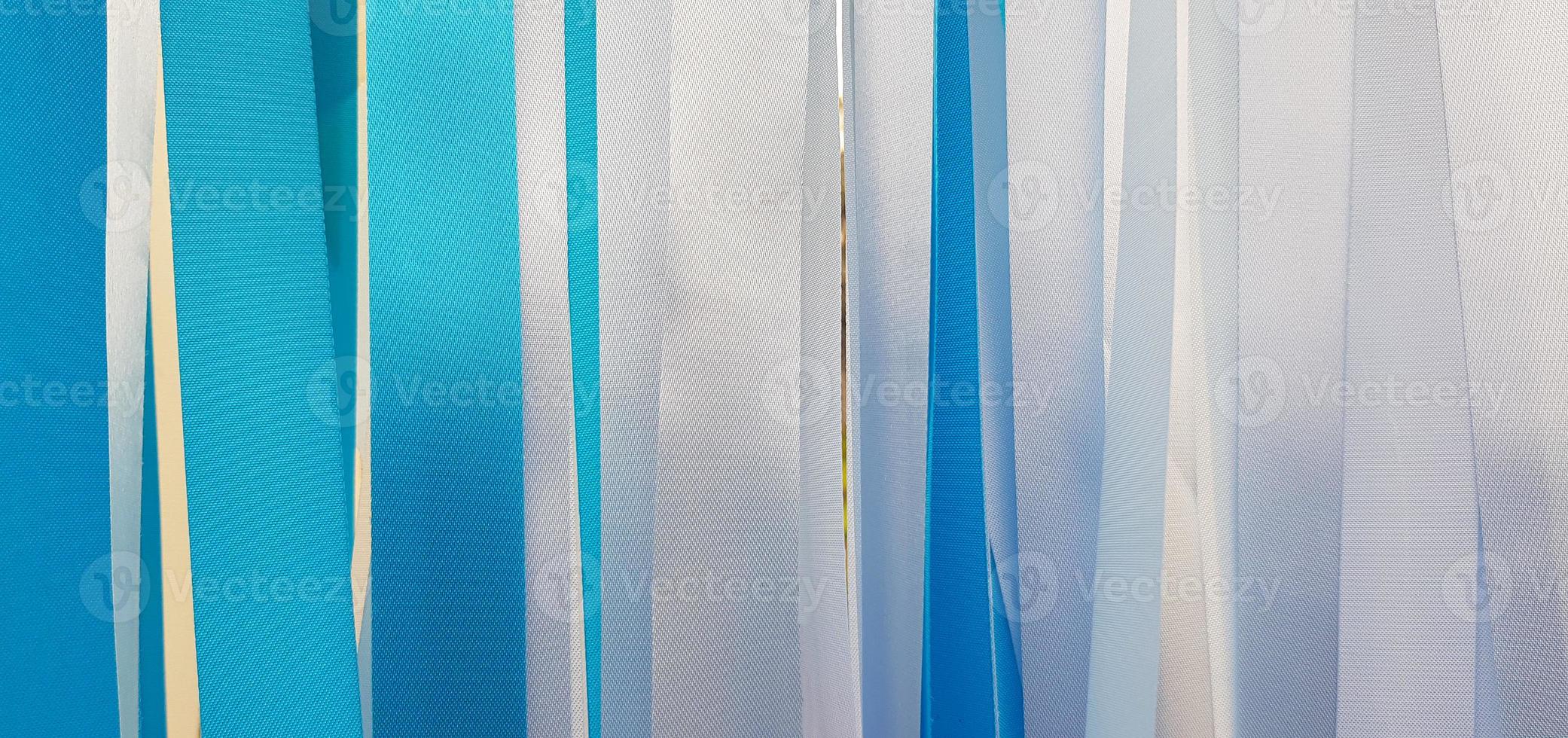 Blue and white ribbon background or wall. Pastel and colorful paper or fabric decoration in party, festival, wedding, new year and celebration concept. photo