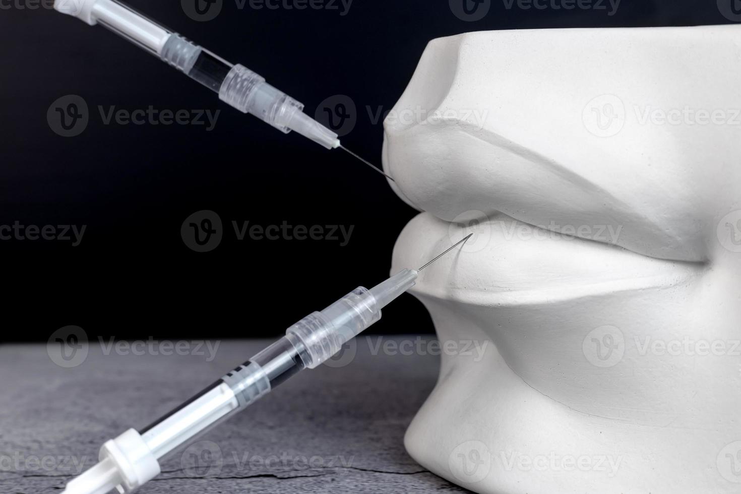 Medical syringes and white plaster lips. photo