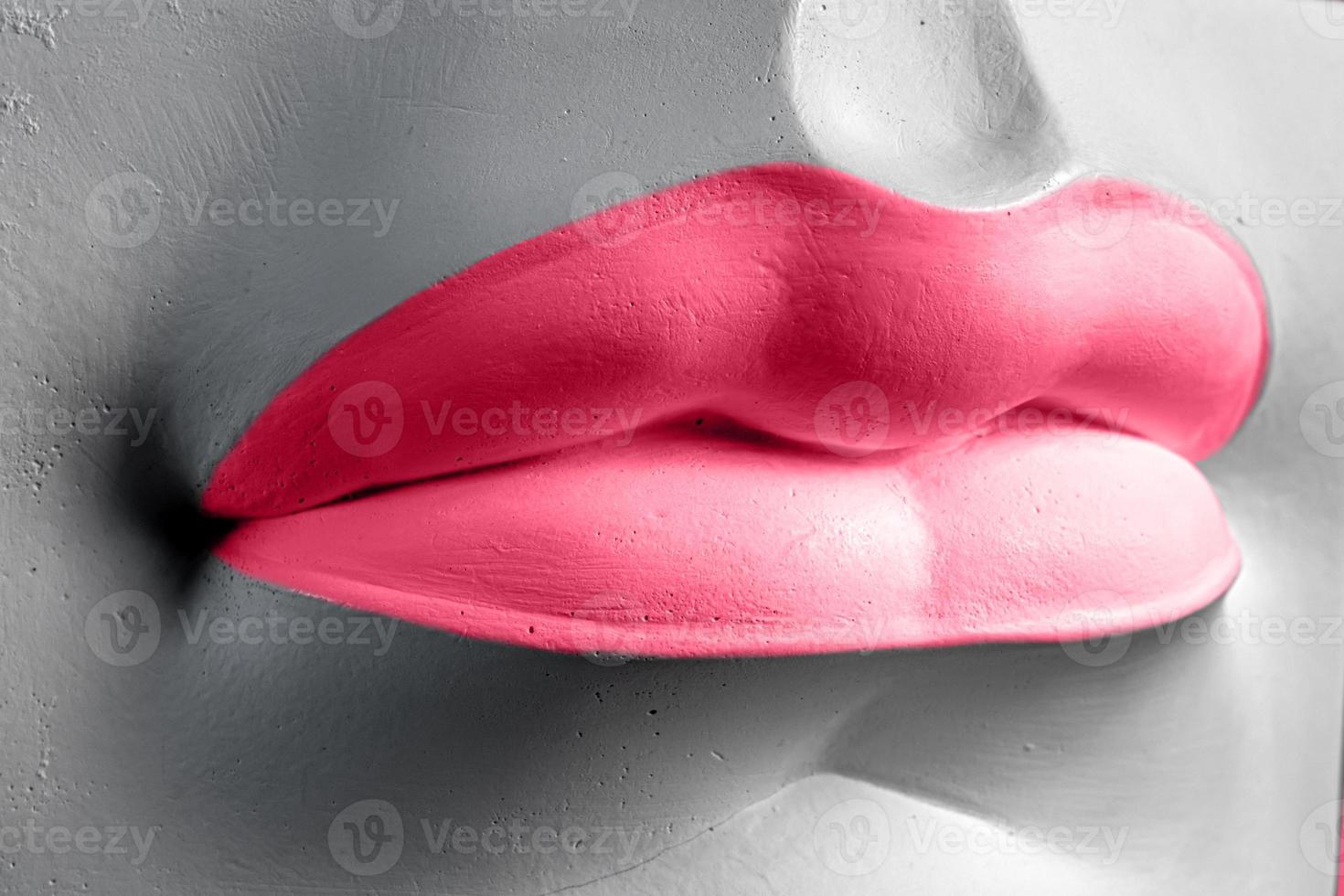 Close-up of a Lip in Viva magenta. Plaster elements in a modern style. Creative figurine made of plaster. photo