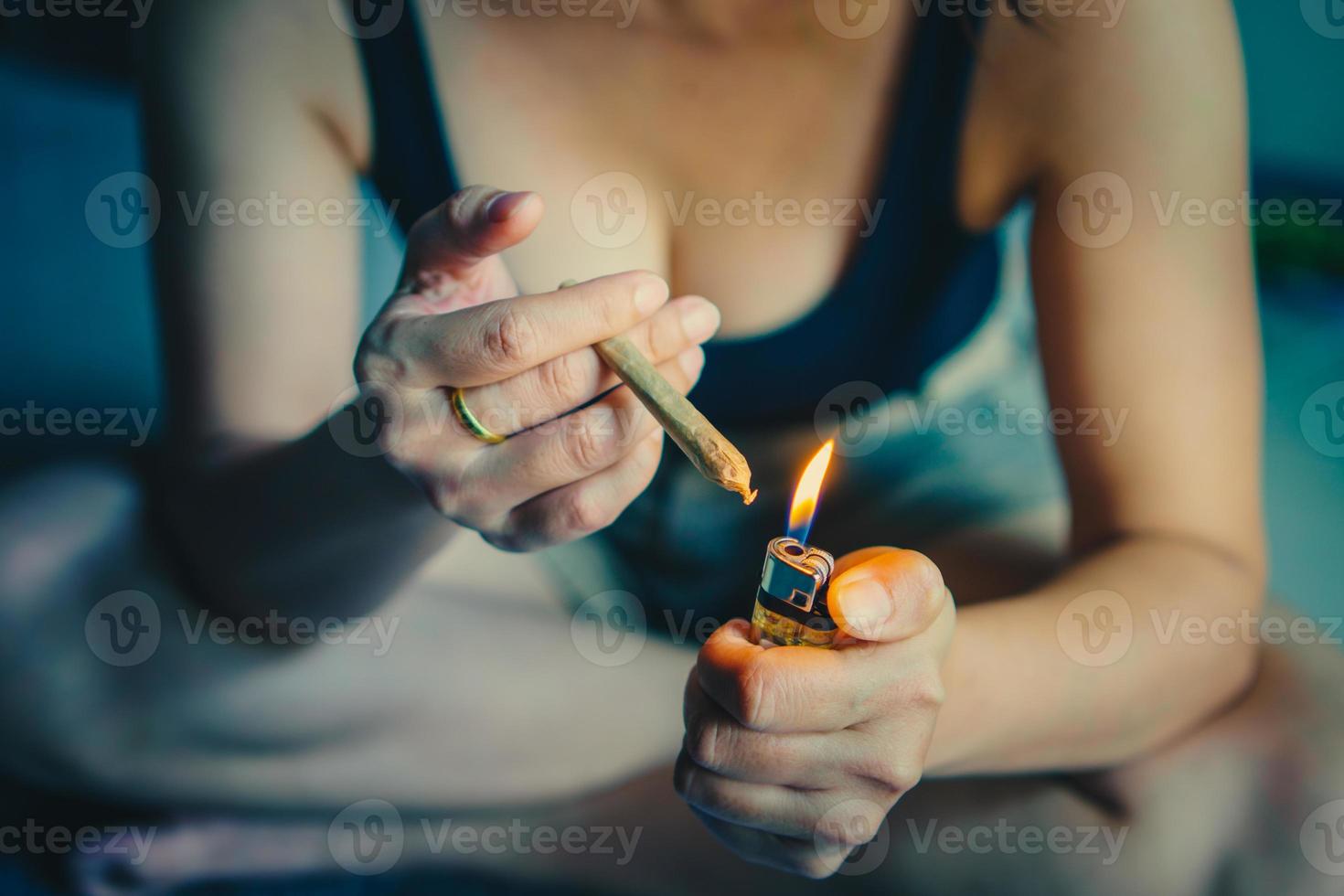 Women preparing lighting up cigarettes with lighter. cannabis smoker rolling marijuana cannabis joint. Drugs narcotic concept. Legal Marijuana. photo