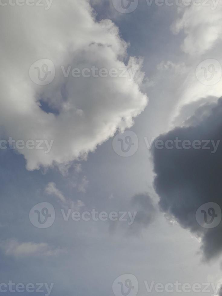 Beautiful black and white clouds on deep blue sky background. Large bright soft fluffy clouds are cover the entire blue sky. photo