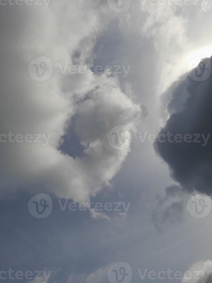 Beautiful black and white clouds on deep blue sky background. Large bright soft fluffy clouds are cover the entire blue sky. photo