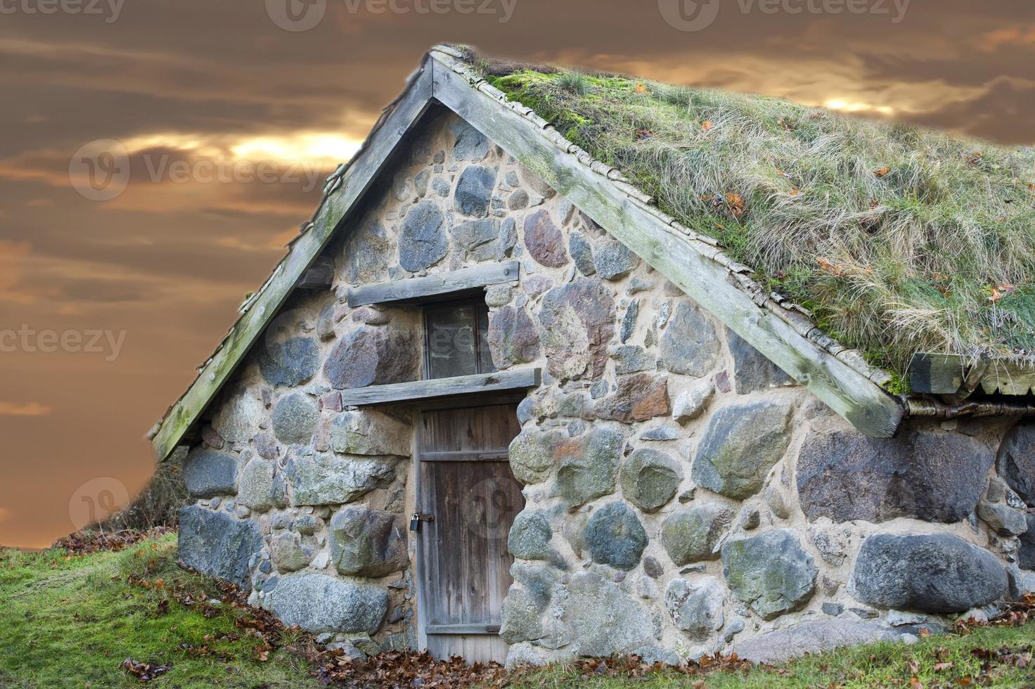 stone cabin with grass roof photo