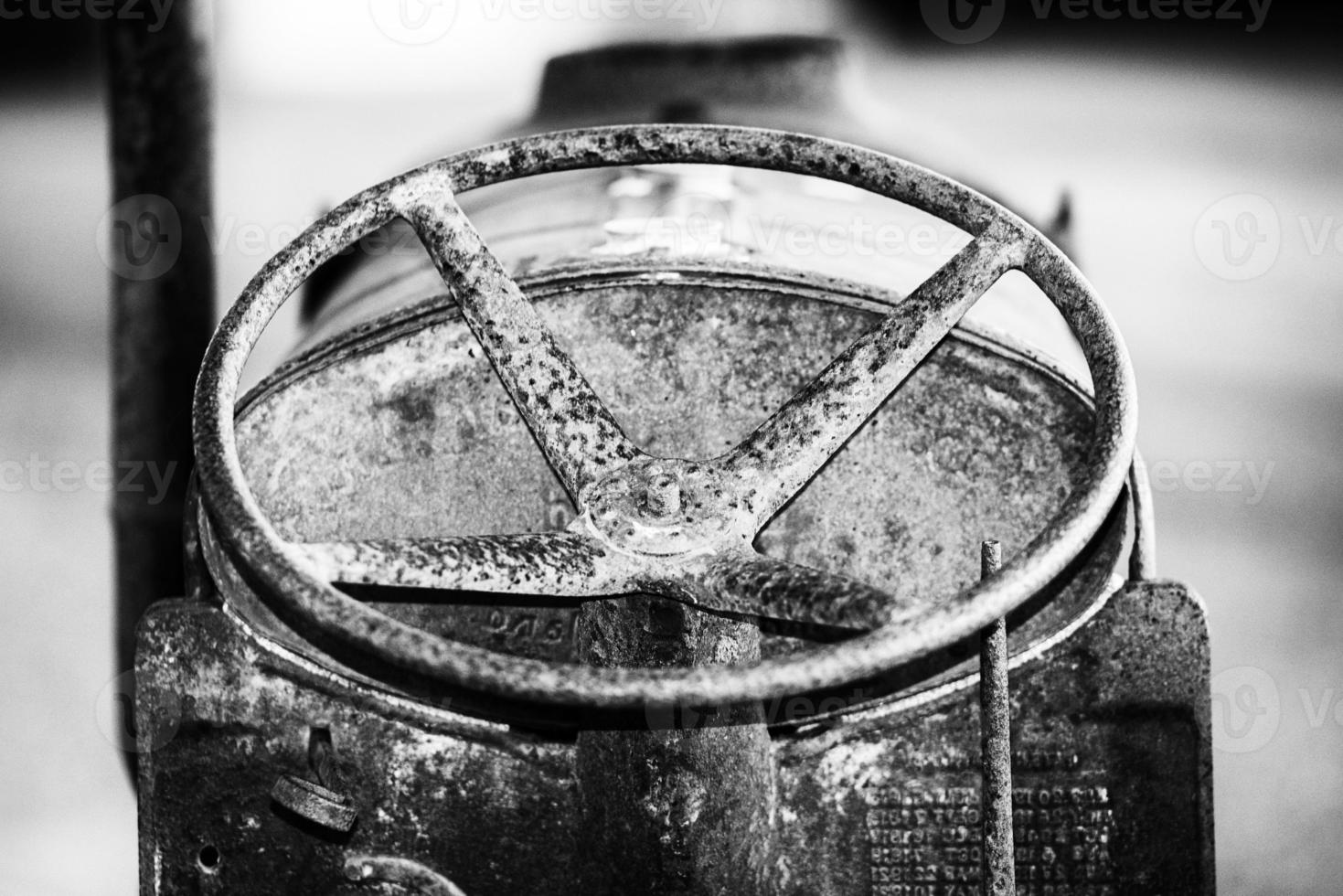 Old rusted antique tractor detail in black and white photo