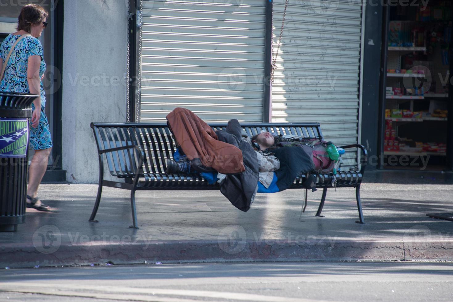 LOS ANGELES, USA - AUGUST 1, 2014 - Homeless sleeping on a bench on  Walk of Fame photo