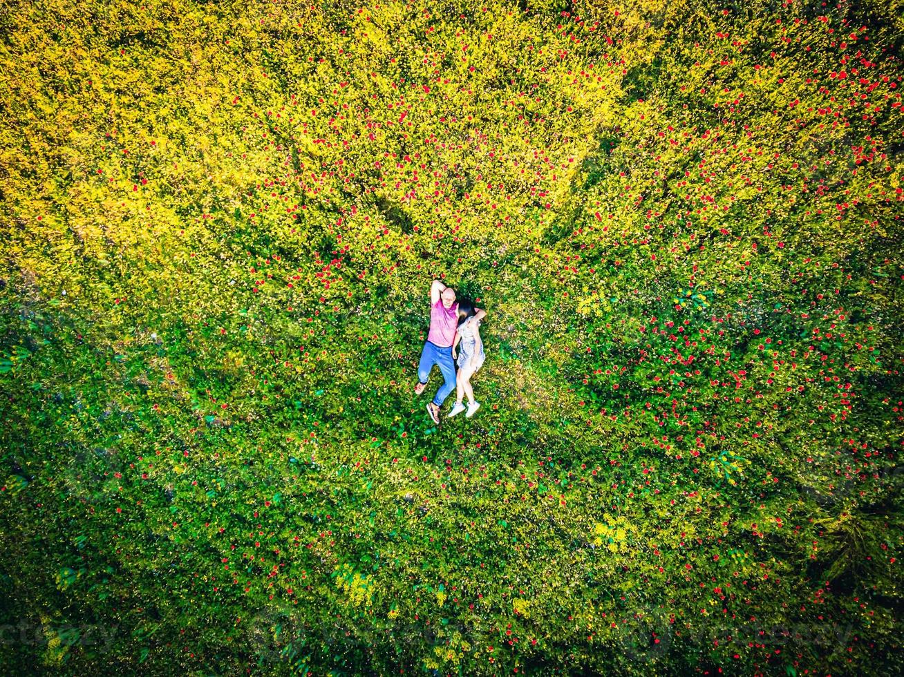 happy couple in love laying on the field on summer day. top view. Intimacy and healthy relationship concept photo