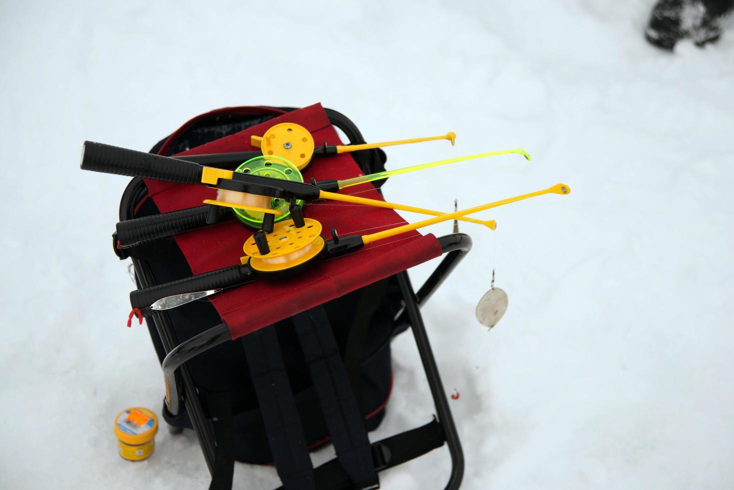 Unrecognizable person holding a plastic ice fishing rod on an iced lake. photo