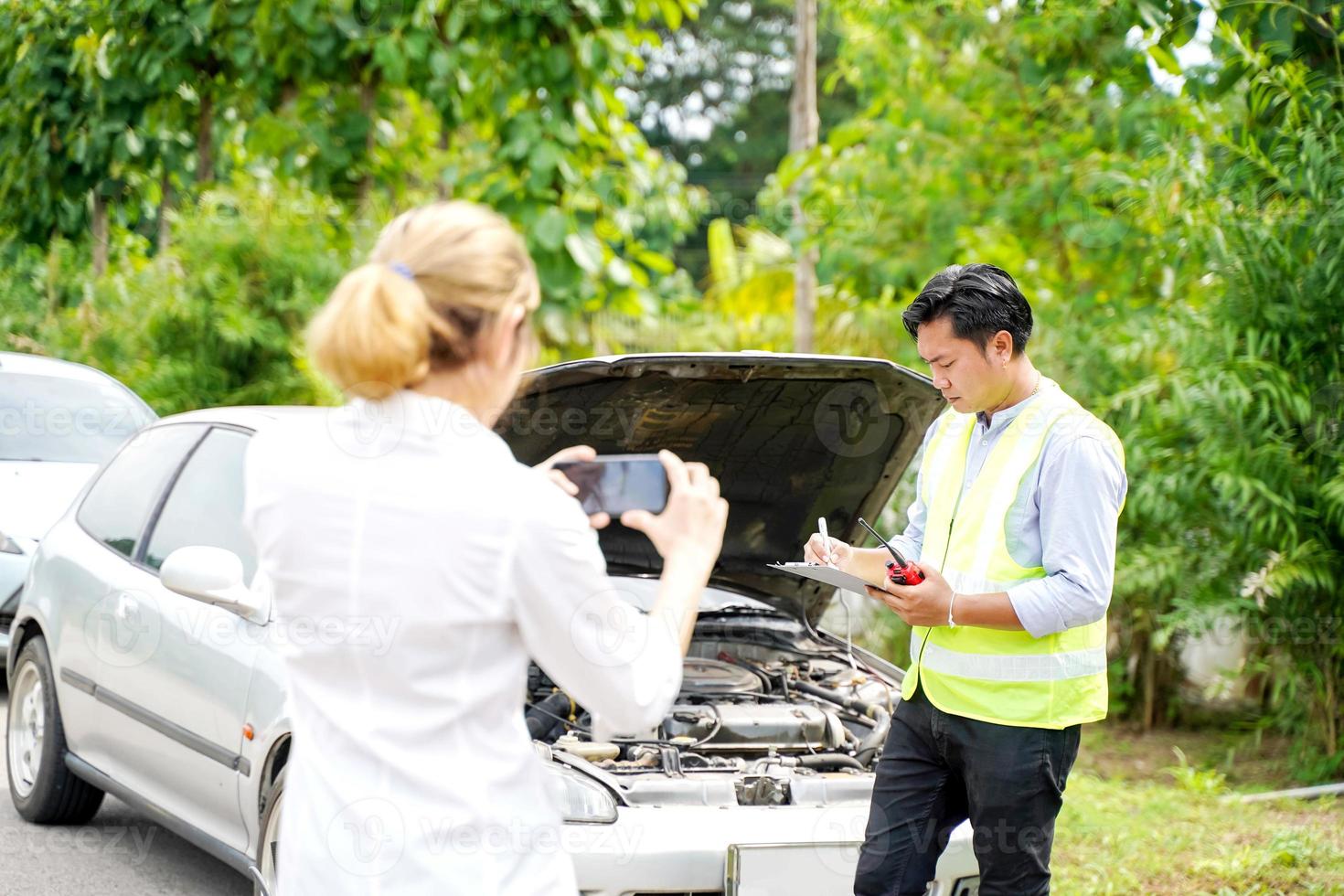 Closeup insurance company officers are using mobile phones to take photos as evidence for customer insurance car claims out door background.