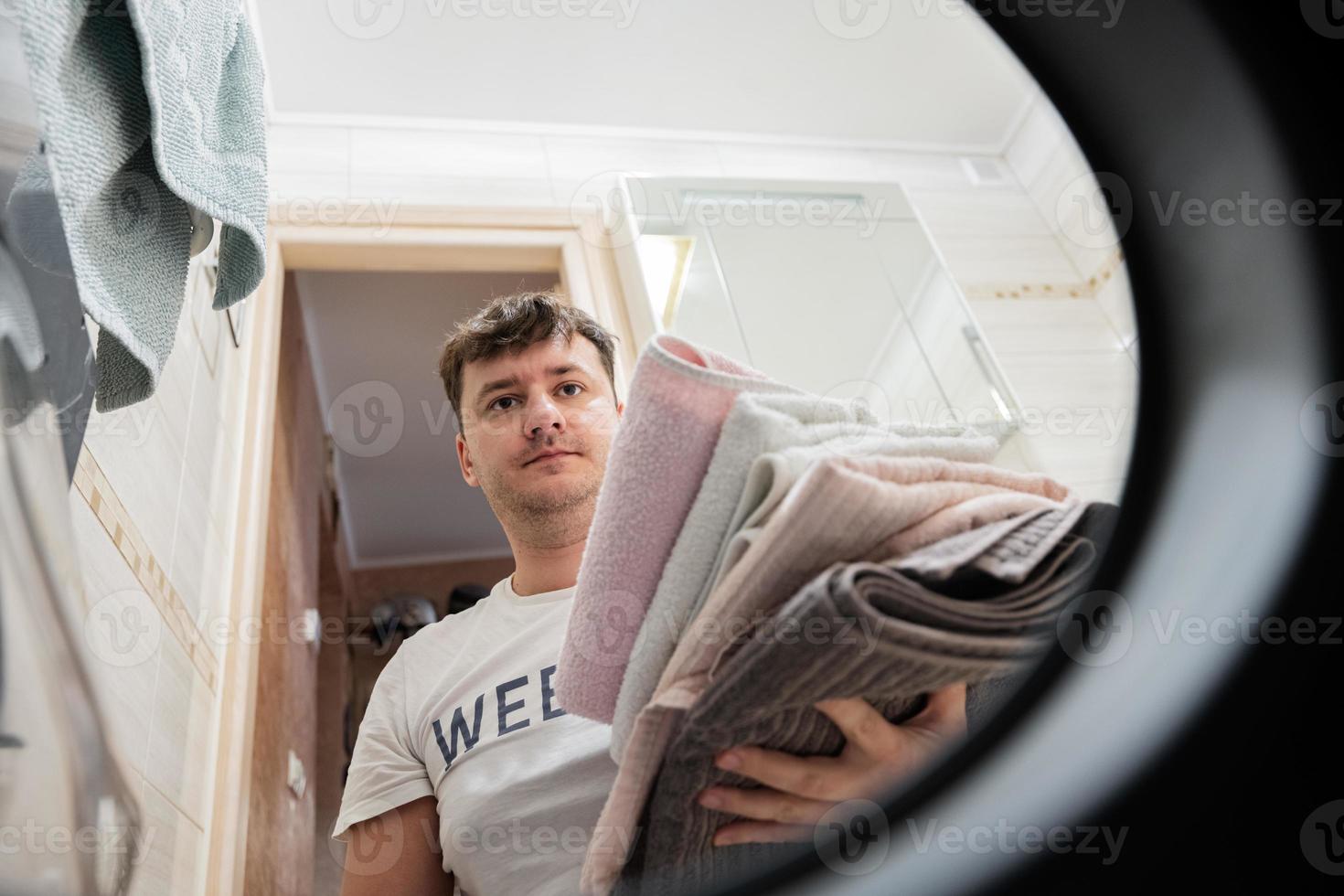 hombre ver desde Lavado máquina adentro. masculino lo hace lavandería diario rutina. foto