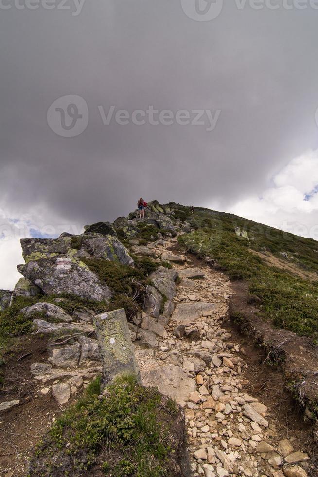 Hikers with trekking poles on mountain cliff scenic photography photo