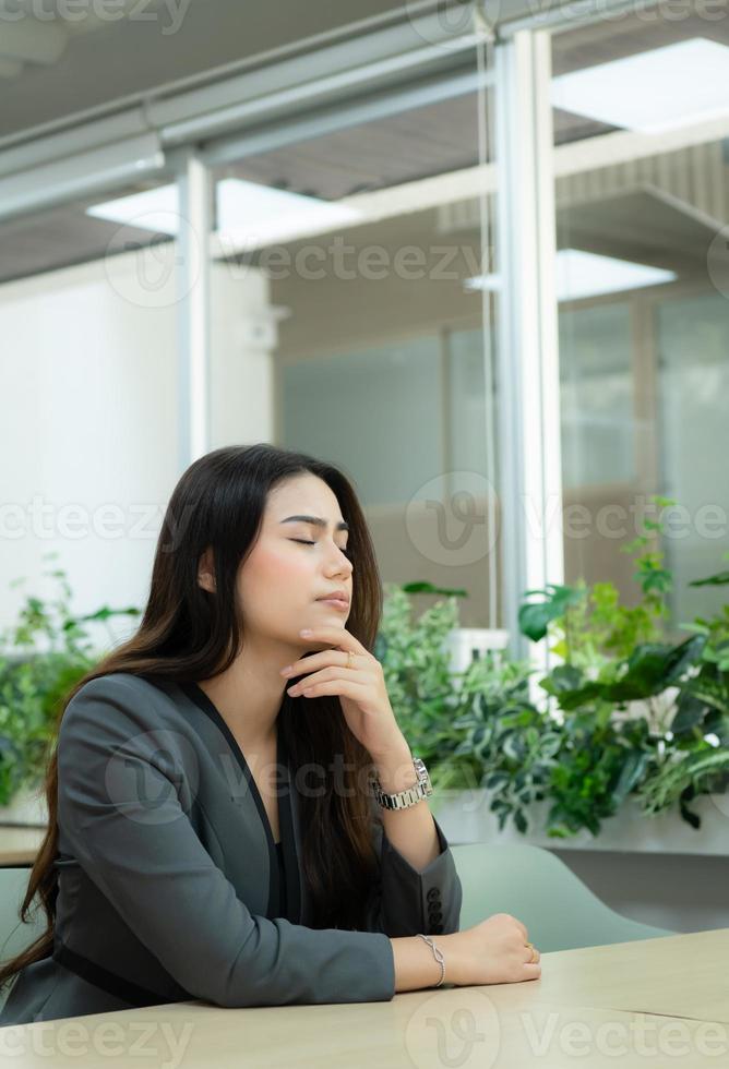 retrato de un principiante mujer de negocios en un nuevo emprendimiento clausura su ojos a descanso ellos en su oficina habitación. foto