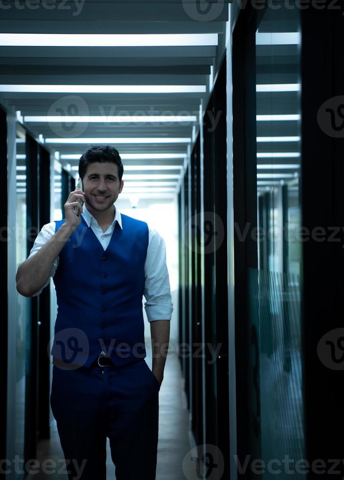 negocio hombre en el corredor de el conferencia habitación, hablando a un asistente en el teléfono a pedir para algunos detalles. foto