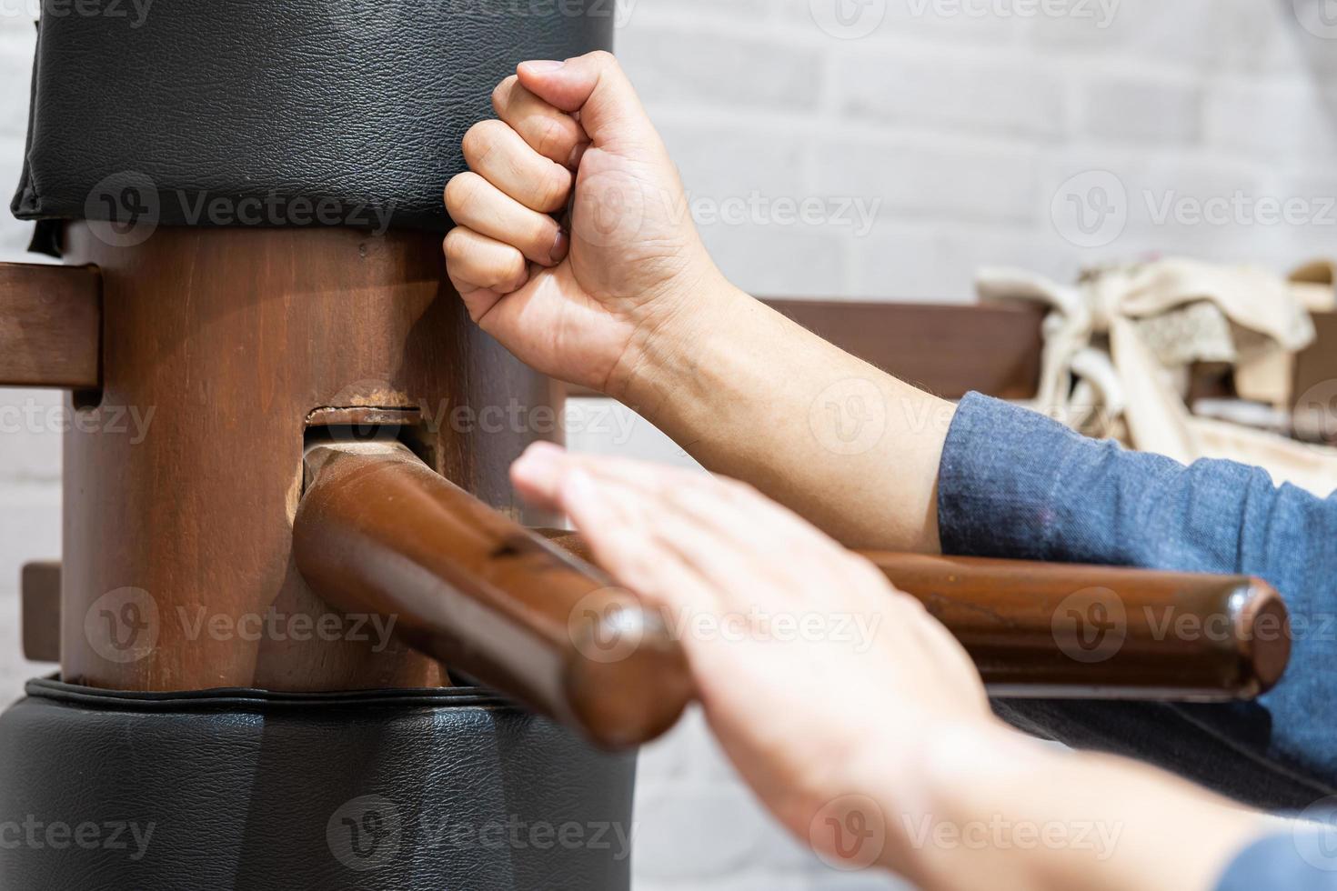 Wooden dummy training in Wing Chun Kung Fu. The athlete shows techniques Wing Chun KungFu wooden dummy. photo