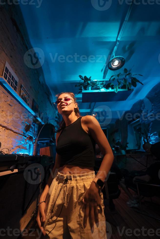 Beautiful female DJ dancing to techno in a small club photo