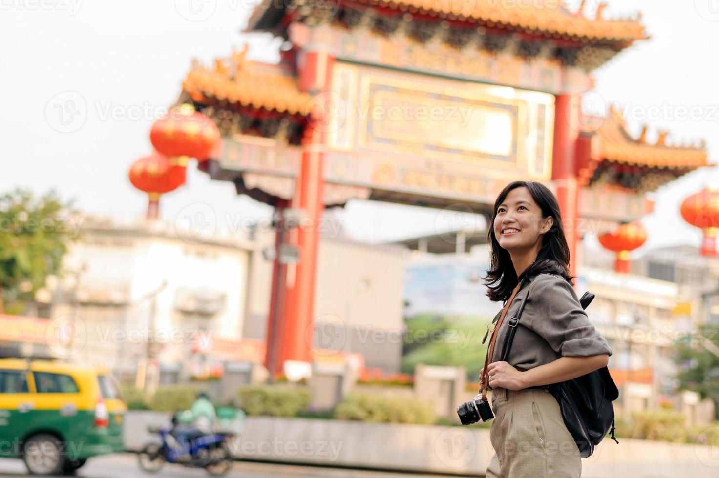 Young Asian woman backpack traveler enjoying China town street food market in Bangkok, Thailand. Traveler checking out side streets. photo