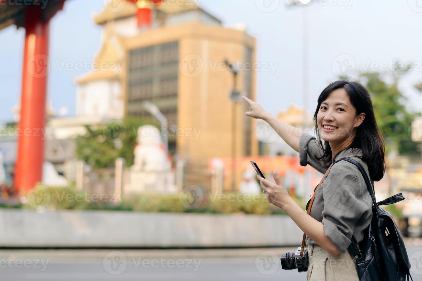 Young Asian woman backpack traveler enjoying China town street food market in Bangkok, Thailand. Traveler checking out side streets. photo