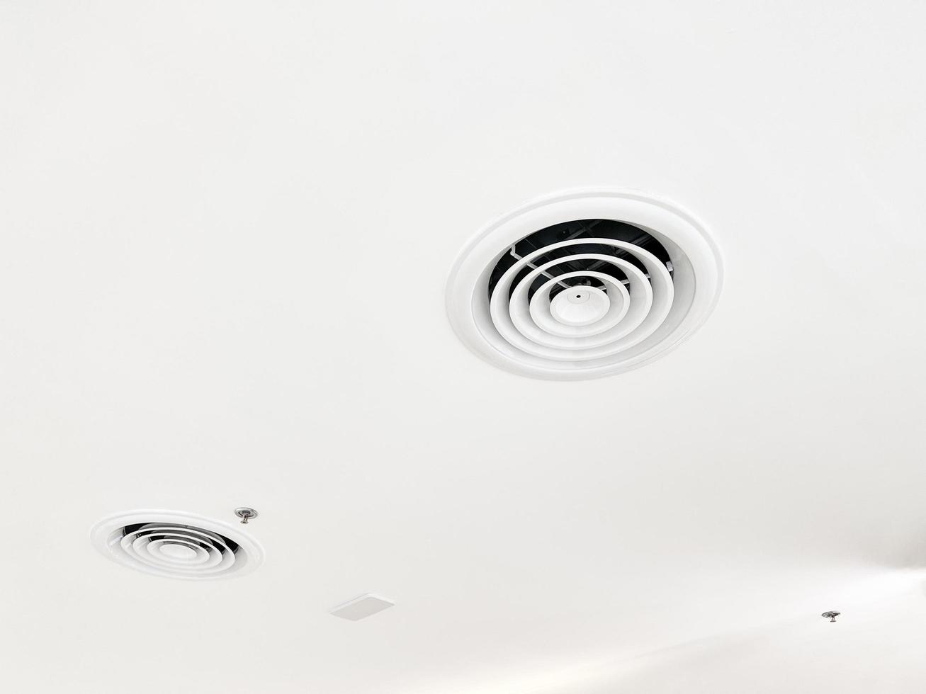 Ceiling mounted cassette type air conditioner and modern lamp light on white ceiling. duct air conditioner for home or office photo