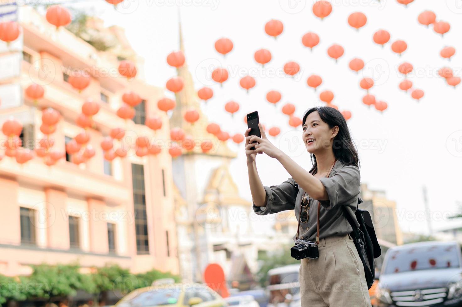 Young Asian woman backpack traveler enjoying China town street food market in Bangkok, Thailand. Traveler checking out side streets. photo