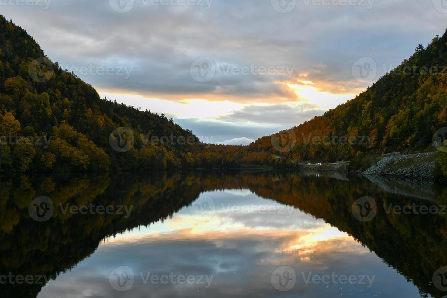 Peak fall foliage in Keene, New York by Cascade Lake at sunset. photo