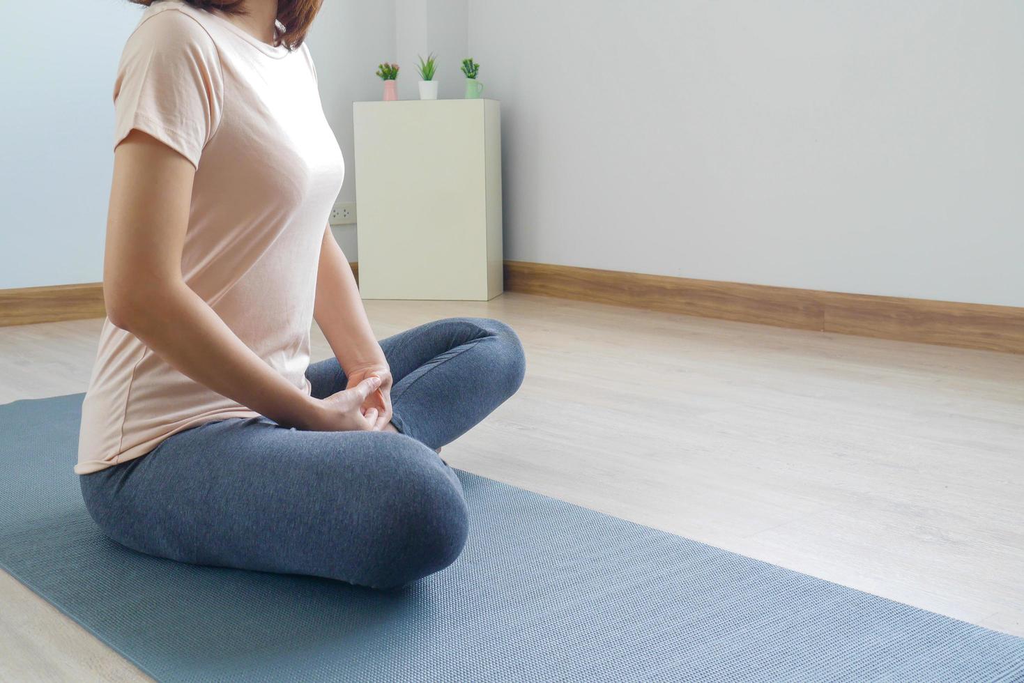 Woman sitting meditation, doing yoga, is alone in the room at home, relax. Practicing meditation Yoga and healthy living concepts photo