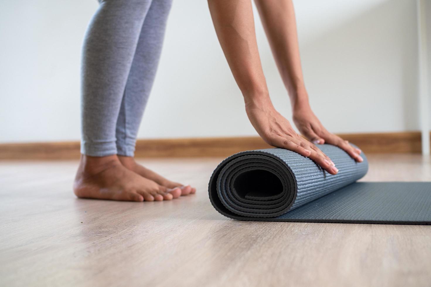 Slim Asian women collecting yoga mats after exercising photo