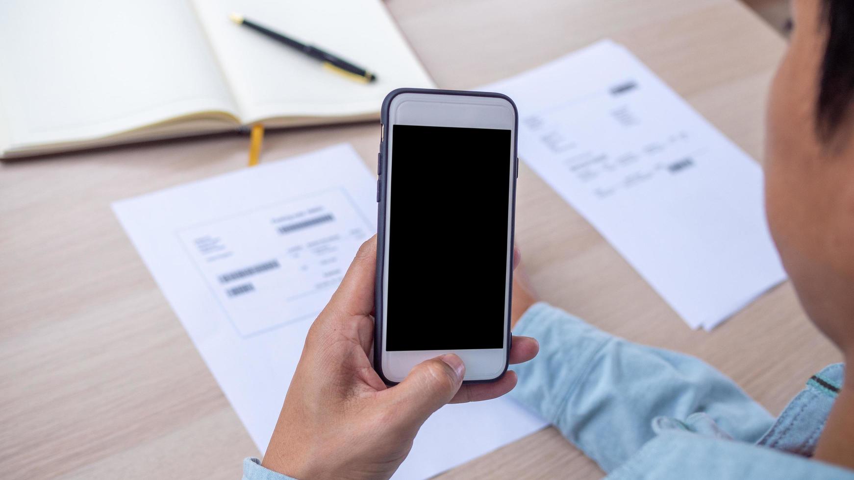 The hand uses the phone to scan the QR code or barcode to receive a discount from paying electricity bills at the office. Online payment concept photo