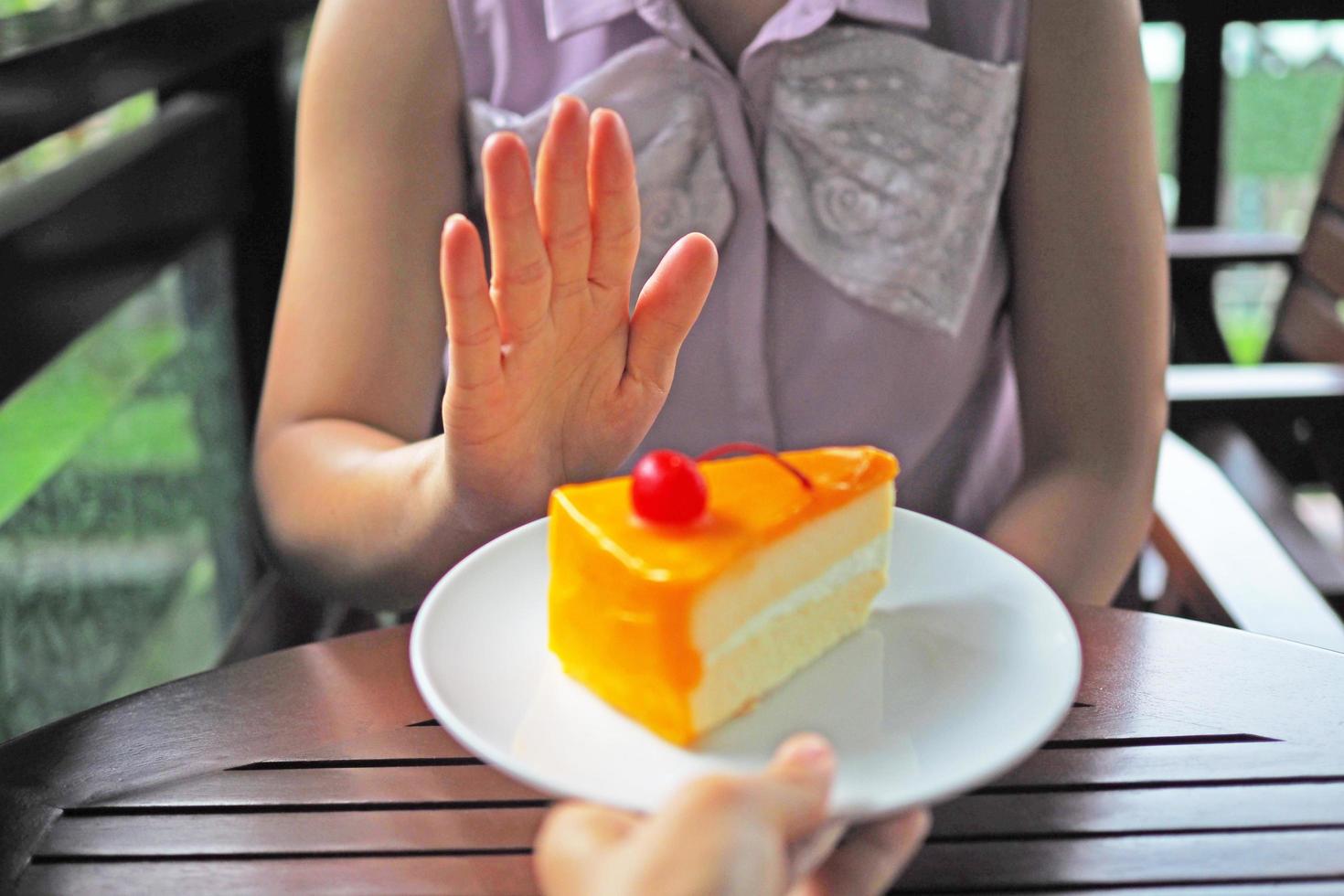 el mujer son perdiendo peso. escoger no a obtener un plato de pastel ese amigos enviar. foto